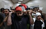 Des pleureurs transportant le corps d'Odeh Awawdeh, 29 ans, tué par des tirs qui auraient été effectués par un résident d'implantation, dans la ville de Deir Dibwan, en Cisjordanie, vers un hôpital de Ramallah, le 22 avril 2026. (Crédit : Zain Jaafar/AFP)