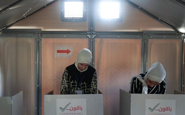 Une candidate gazaouie (à gauche) et une électrice votant dans un bureau de vote improvisé lors des élections municipales, à Deir el-Balah, dans la bande de Gaza, le 25 avril 2026. (Crédit : Eyad Baba/AFP)