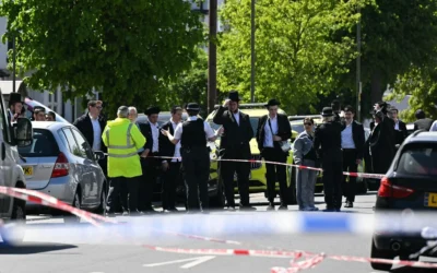 Des habitants observent depuis l’extérieur d’une zone bouclée à la suite d’une attaque à l’arme blanche dans le quartier de Golders Green, au nord de Londres, le 29 avril 2026 (Crédit: JUSTIN TALLIS / AFP)