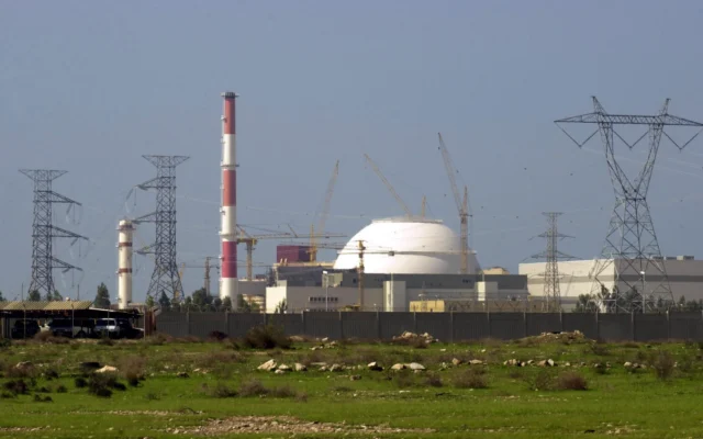 Le bâtiment du réacteur de la centrale nucléaire iranienne et des poteaux électriques sont visibles à Bushehr, en Iran, à 1 245 kilomètres au sud de la capitale Téhéran, le 27 février 2005. (Crédit : AP/Vahid Salemi)