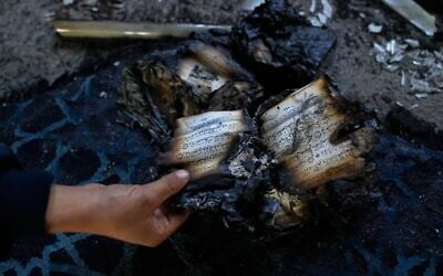Illustration : Un garçon examinant des exemplaires brûlés du Coran à l'intérieur d'une mosquée incendiée et vandalisée par des extrémistes juifs, dans la ville de Deir Istiya, en Cisjordanie, le 13 novembre 2025. (Crédit : Nasser Nasser/AP)