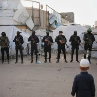 Des terroristes armés du Hamas et du Jihad islamique palestinien saluant les fidèles rassemblés pour la prière de l'Aïd al-Fitr, à Gaza-City, le 20 mars 2026. (Crédit : Abdel Kareem Hana /AP)