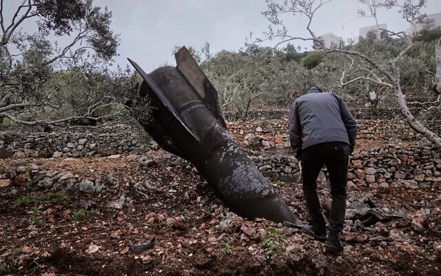 Un homme inspectant l'épave d'un missile iranien qui s'est écrasé près du village de Marda, en Cisjordanie, le 31 mars 2026. (Crédit : Majdi Mohammed/AP Photo)