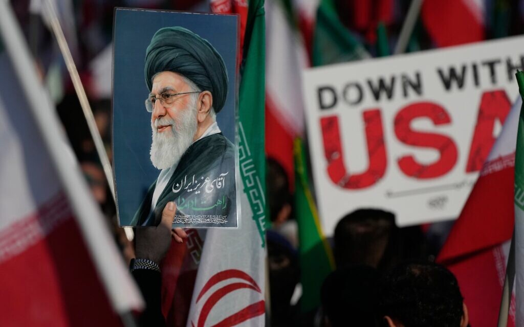 Une affiche représentant le défunt guide suprême iranien, l'ayatollah Ali Khamenei, et une pancarte anti-américaine brandies lors du cortège funèbre d'Alireza Tangsiri, chef de la marine du Corps des Gardiens de la Révolution islamique, et d'autres personnes éliminés lors de frappes israéliennes fin mars, à Téhéran, en Iran, le 1ᵉʳ avril 2026. (Crédit : Vahid Salemi/AP Photo)