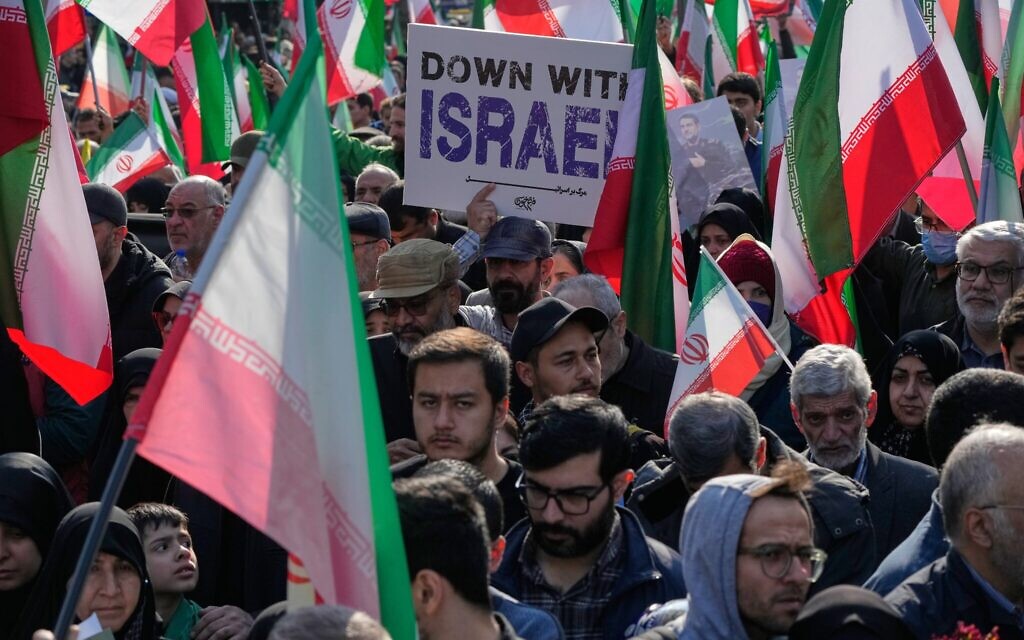 Un homme brandissant une pancarte anti-Israël lors du cortège funèbre d'Alireza Tangsiri, chef de la marine du Corps des Gardiens de la Révolution islamique (CGRI), et d'autres personnes tuées lors des frappes israéliennes fin mars, à Téhéran, en Iran, le 1ᵉʳ avril 2026. (Crédit : Vahid Salemi/AP Photo)