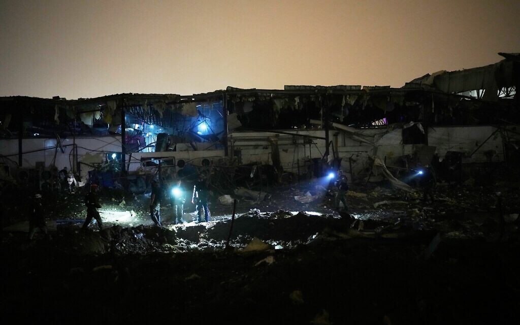 Les forces de sécurité israéliennes et les équipes de secouristes inspectant un site touché par un missile iranien, à Petah Tikva, le 2 avril 2026. (Crédit : Ohad Zwigenberg/AP Photo)