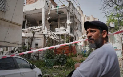 Un homme se tient devant une maison touchée par un missile à fragmentation iranien à Ramat Gan, le 4 avril 2026. (Crédit : Maya Levin/AP) Un homme se tient devant une maison touchée par un missile à fragmentation iranien à Ramat Gan, le 4 avril 2026. (Crédit : Maya Levin/AP)