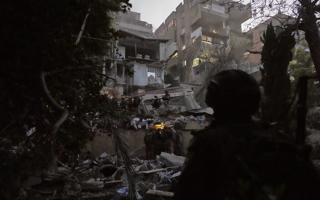 Les forces de sécurité et les équipes de secours israéliennes interviennent au milieu des décombres d'un immeuble résidentiel touché par un missile iranien à Haïfa, le 5 avril 2026. (Crédit : AP Photo/Ariel Schalit) Les forces de sécurité et les équipes de secours israéliennes interviennent au milieu des décombres d'un immeuble résidentiel touché par un missile iranien à Haïfa, le 5 avril 2026. (Crédit : AP Photo/Ariel Schalit)
