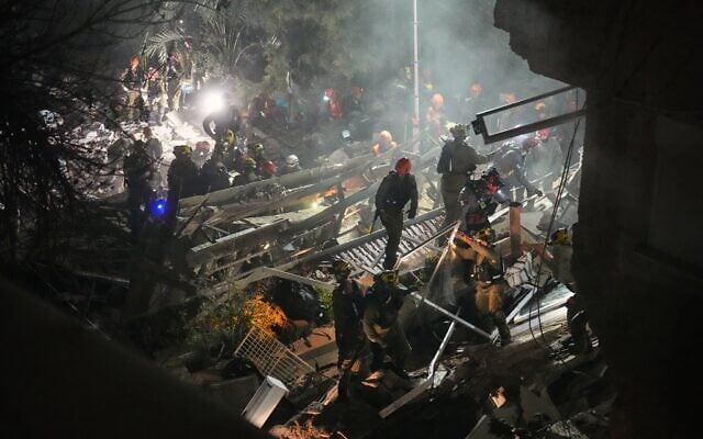 Les forces de sécurité et les équipes de secours israéliennes intervenant au milieu des décombres d’un immeuble résidentiel frappé par un missile iranien, à Haïfa, le 5 avril 2026. (Crédit : Ariel Schalit/AP Photo) Les forces de sécurité et les équipes de secours israéliennes intervenant au milieu des décombres d’un immeuble résidentiel frappé par un missile iranien, à Haïfa, le 5 avril 2026. (Crédit : Ariel Schalit/AP Photo)