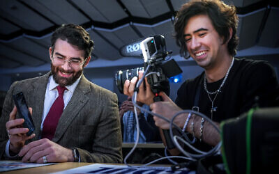 Le streamer Hasan Piker, à gauche, montre son téléphone lors d’un live sur Twitch tandis que le producteur Mauricio Miranda filme, lors d’un événement de campagne pour Abdul El-Sayed, candidat progressiste à la primaire démocrate pour le Sénat américain dans le Michigan, le 7 avril 2026, à l’université du Michigan à Ann Arbor. (Crédit : Julia Demaree Nikhinson/AP)