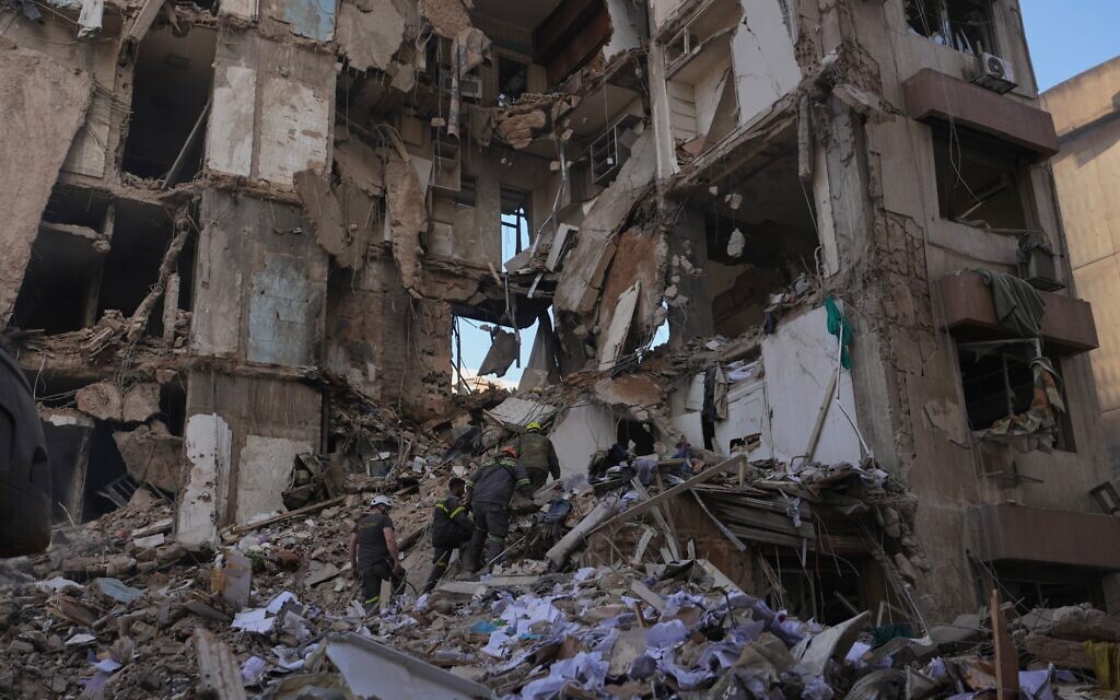 Des secouristes libanais recherchant des victimes dans les décombres d'un immeuble détruit par une frappe aérienne israélienne la veille, alors que les frappes israéliennes visent les infrastructures du groupe terroriste chiite libanais du Hezbollah, dans le centre de Beyrouth, au Liban, le 9 avril 2026. (Crédit : Hassan Ammar/AP)
