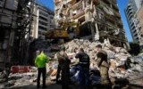 Des membres de la défense civile libanaise et des soldats de l’armée participant aux recherches de victimes dans les décombres d’un bâtiment détruit lors d’une frappe aérienne israélienne la veille, dans le centre de Beyrouth, au Liban, le 9 avril 2026. (Crédit : Hussein Malla/AP)