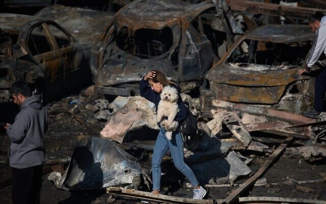 Une femme passant devant des voitures calcinées au lendemain d'une frappe aérienne israélienne, à Beyrouth, au Liban, le 9 avril 2026. (Crédit : Emilio Morenatti/AP)