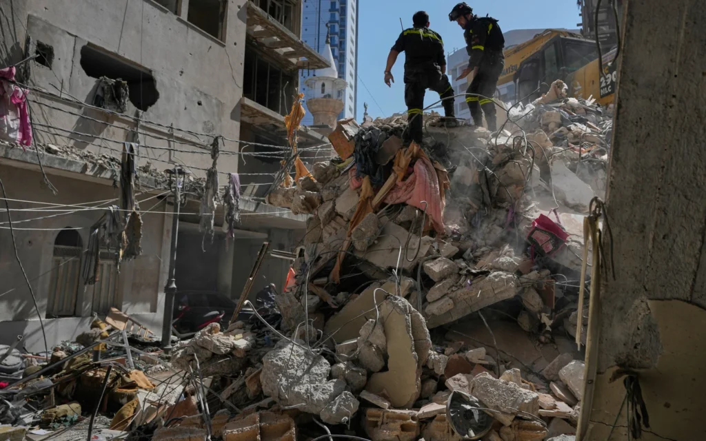 Des membres de la défense civile libanaise inspectent les décombres d’un immeuble détruit lors d’une frappe aérienne israélienne, dans le cadre d’attaques visant les infrastructures militaires du groupe terroriste chiite libanais du Hezbollah, à Beyrouth, au Liban, le 9 avril 2026. (Crédit : Hussein Malla/AP)
