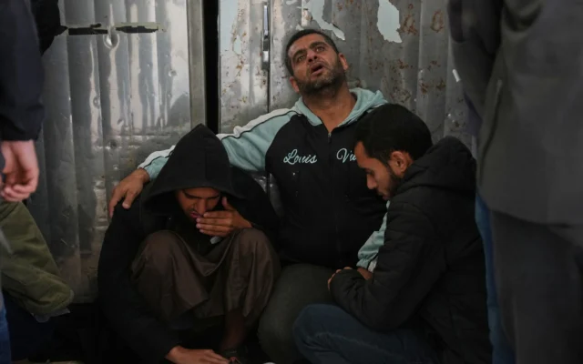 Des Palestiniens pleurent devant les corps d'hommes tués lors d'une frappe israélienne dans le camp de réfugiés d'Al-Bureij, avant leurs funérailles à l'hôpital Al-Aqsa de Deir al-Balah, au centre de la bande de Gaza, le 11 avril 2026. (Crédit: AP Photo/Abdel Kareem Hana)