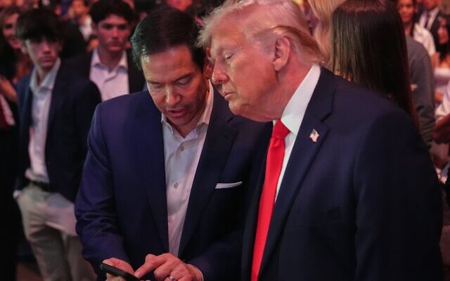 Le président Donald Trump s'entretenant avec le secrétaire d'État Marco Rubio lors de l'UFC 327, au Kaseya Center de Miami, en Floride, le 11 avril 2026. (Crédit : Julia Demaree Nikhinson/POOL/AFP)