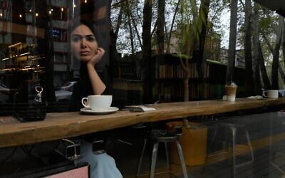 Une femme assise dans un café du nord de Téhéran, en Iran, le 12 avril 2026. (Crédit : Vahid Salemi/AP)