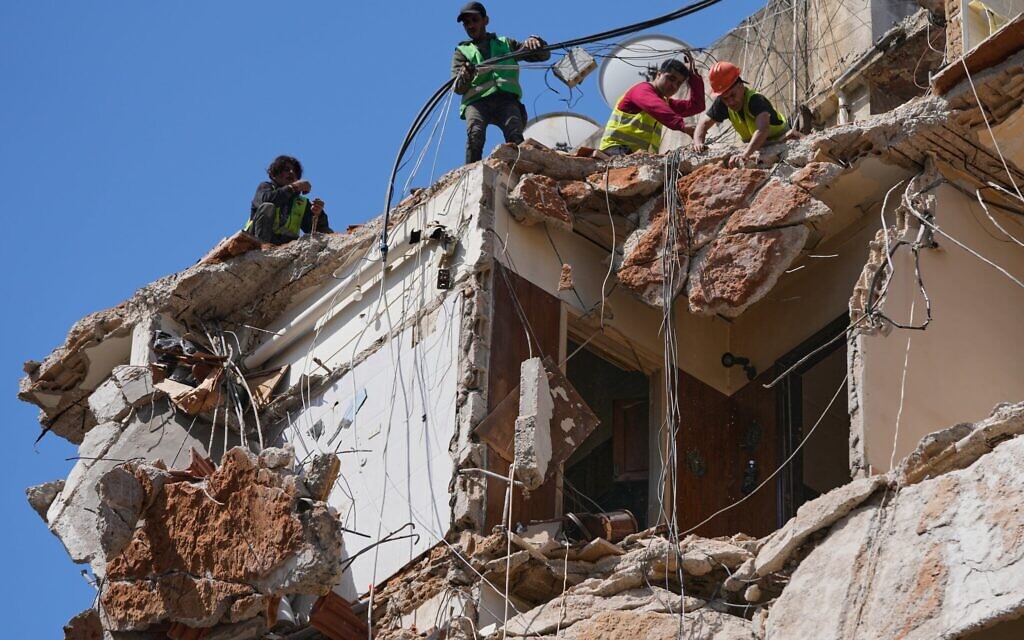 Des ouvriers déblayant les décombres tandis que les sauveteurs poursuivent leurs recherches pour retrouver une femme et une fillette portées disparues dans un bâtiment détruit lors d'une frappe aérienne israélienne le 8 avril, à Beyrouth, au Liban, le 13 avril 2026. (Crédit : Hussein Malla/AP Photo)