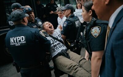 Des manifestants du groupe antisioniste Jewish Voice for Peace (JVP) arrêtés après avoir bloqué la circulation lors d'une manifestation devant le bureau new-yorkais du sénateur américain Chuck Schumer, pour réclamer la fin de la guerre menée par les États-Unis et Israël contre la République islamique d'Iran et s'opposer au soutien américain en matière d'armement, à New York, le 13 avril 2026. (Crédit : Andres Kudacki/AP)