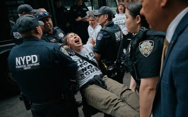Des manifestants du groupe antisioniste Jewish Voice for Peace (JVP) arrêtés après avoir bloqué la circulation lors d'une manifestation devant le bureau new-yorkais du sénateur américain Chuck Schumer, pour réclamer la fin de la guerre menée par les États-Unis et Israël contre la République islamique d'Iran et s'opposer au soutien américain en matière d'armement, à New York, le 13 avril 2026. (Crédit : Andres Kudacki/AP) Des manifestants du groupe antisioniste Jewish Voice for Peace (JVP) arrêtés après avoir bloqué la circulation lors d'une manifestation devant le bureau new-yorkais du sénateur américain Chuck Schumer, pour réclamer la fin de la guerre menée par les États-Unis et Israël contre la République islamique d'Iran et s'opposer au soutien américain en matière d'armement, à New York, le 13 avril 2026. (Crédit : Andres Kudacki/AP)
