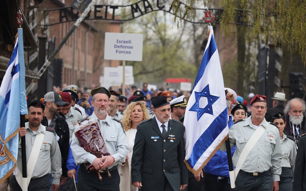 Des personnes participent à la « Marche des Vivants » annuelle, une marche commémorative organisée chaque année entre les anciens camps d'extermination d'Auschwitz et de Birkenau, à Oświęcim, en Pologne, le mardi 14 avril 2026. (Crédit : AP/Beata Zawrzel)