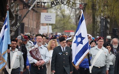 Des personnes participent à la « Marche des Vivants » annuelle, une marche commémorative organisée chaque année entre les anciens camps d'extermination d'Auschwitz et de Birkenau, à Oświęcim, en Pologne, le mardi 14 avril 2026. (Crédit : AP/Beata Zawrzel)
