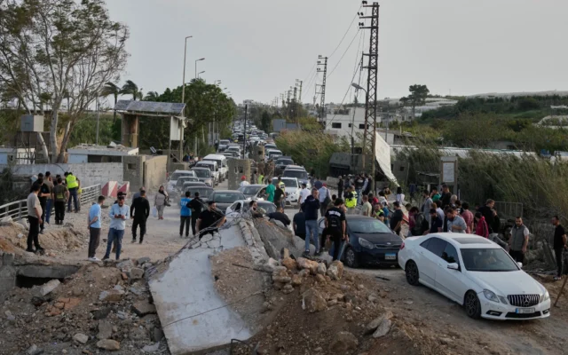 Des personnes déplacées retournent dans leurs villages à la suite d’un cessez-le-feu entre le Hezbollah et Israël traversent le pont endommagé d’Al-Qasmiyeh près de Tyr, dans le sud du Liban, le 17 avril 2026. (Crédit: AP/Mohammed Zaatari)