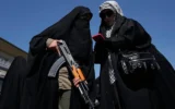 Une femme membre du groupe paramilitaire Basij, affilié aux Gardiens de la Révolution iraniens, tient une arme lors d'un rassemblement organisé par l'État en soutien au guide suprême, à l'occasion de la Journée nationale des filles à Téhéran, en Iran, le 17 avril 2026. (Photo AP/Vahid Salemi)