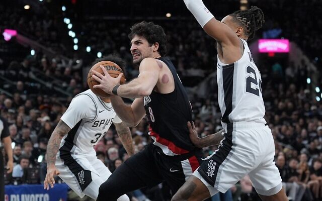 L'ailier des Portland Trail Blazers, Deni Avdija (8), passant devant le meneur des San Antonio Spurs, Devin Vassell (24), lors de la première mi-temps du deuxième match de la série du premier tour des playoffs de la NBA, à San Antonio, le 21 avril 2026. (Crédit : Eric Gay/AP) L'ailier des Portland Trail Blazers, Deni Avdija (8), passant devant le meneur des San Antonio Spurs, Devin Vassell (24), lors de la première mi-temps du deuxième match de la série du premier tour des playoffs de la NBA, à San Antonio, le 21 avril 2026. (Crédit : Eric Gay/AP)