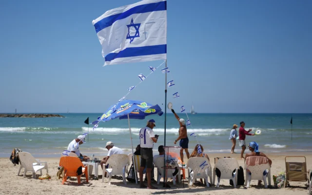 Des gens sur la plage lors des célébrations de la fête de l'Indépendance à Tel Aviv, le 22 avril 2026. (Crédit: AP/Ariel Schalit)
