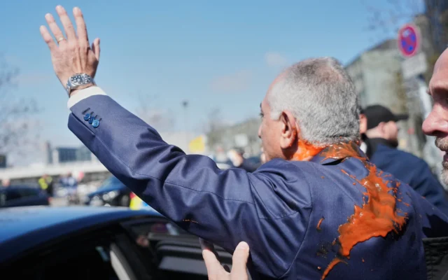 Reza Pahlavi, le fils en exil du shah d'Iran, salue ses partisans après qu'un agresseur lui a jeté un liquide rouge à la suite d'une conférence de presse à Berlin, en Allemagne, le 23 avril 2026. (Crédit: AP Photo/Markus Schreiber)
