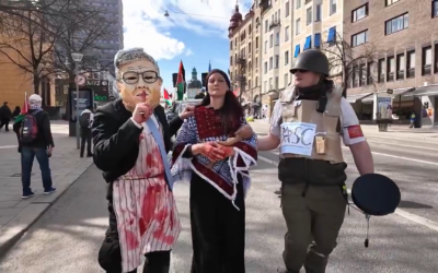 La représentation explicite d'un juif recouvert de sang paraissant égorger une femme palestinienne lors d'une manifestation à Stockholm, en Suède. (Capture d'écran:X)