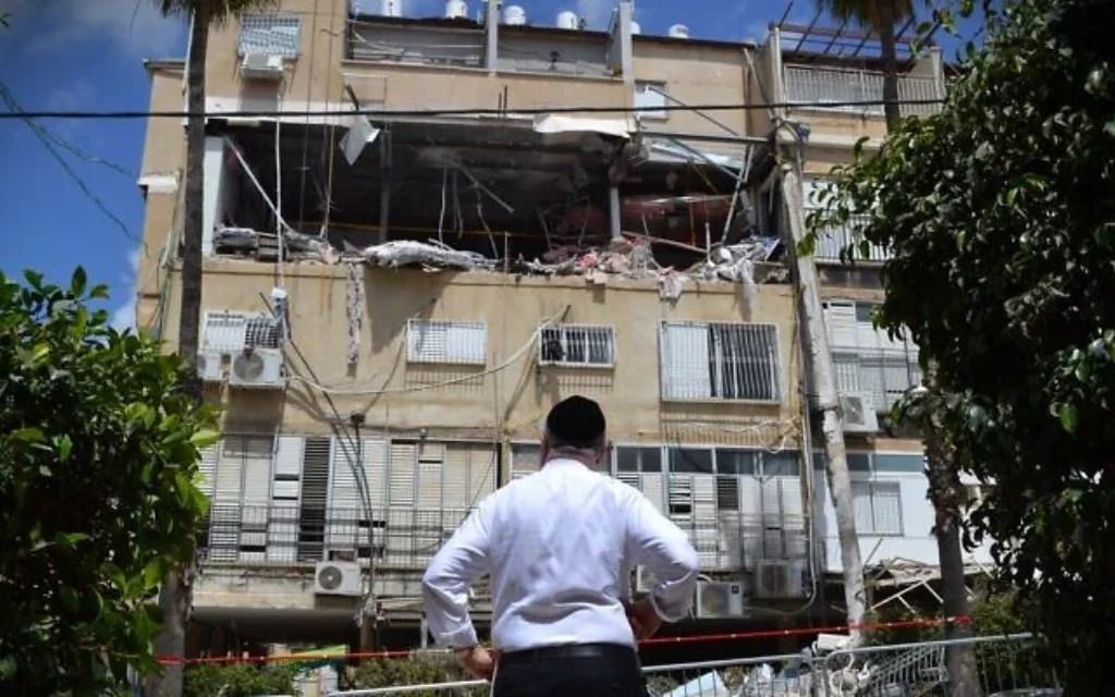 Un homme inspecte les dégâts occasionnés par un missile à fragmentation iranien à Bnei Brak, le 5 avril 2026. (Stav Levaton/Times of Israel)