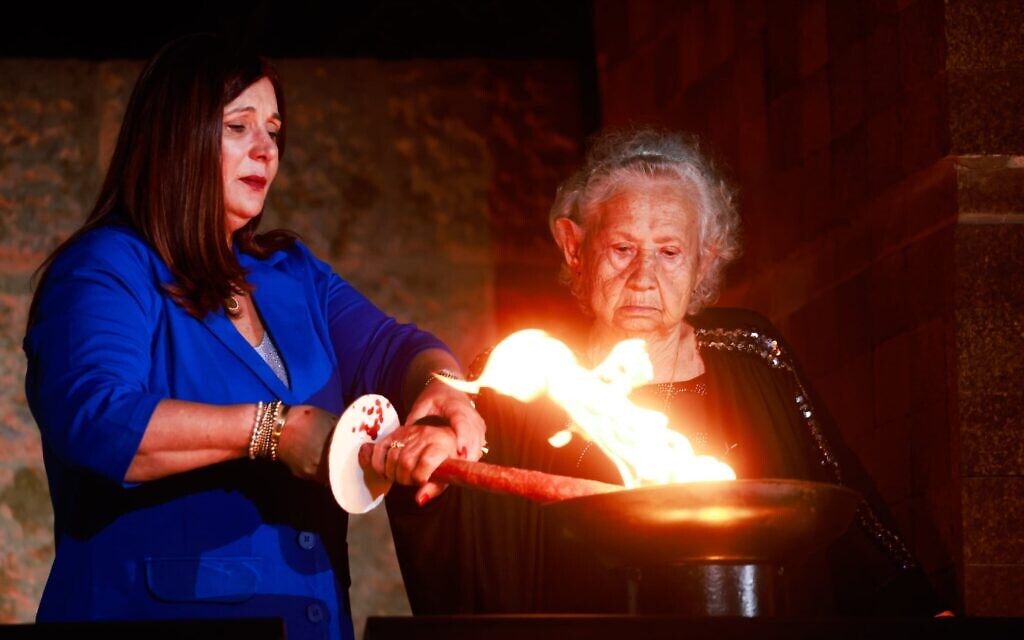 Une survivante de la Shoah allumant l'un des six flambeaux symbolisant les six millions de victimes du génocide nazi, lors de la cérémonie d'ouverture de Yom HaShoah, au musée de la Shoah Yad Vashem, à Jérusalem, le 17 avril 2023. (Crédit : Eric Marmor/Flash90)