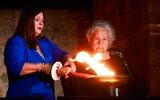 Une survivante de la Shoah allumant l'un des six flambeaux symbolisant les six millions de victimes du génocide nazi, lors de la cérémonie d'ouverture de Yom HaShoah, au musée de la Shoah Yad Vashem, à Jérusalem, le 17 avril 2023. (Crédit : Eric Marmor/Flash90)