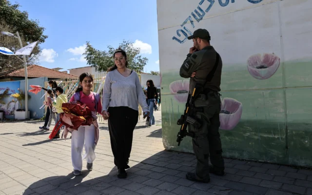 Des parents viennent chercher leurs enfants à la sortie des classes dans une école primaire de la région du Conseil régional de Hof Ashkelon, après que l'armée et le ministère de l'Éducation ont approuvé la reprise partielle des cours dans les zones où le risque de tirs de roquettes est relativement faible et où les écoles disposent d'espaces protégés, le 16 mars 2026. (Crédit : Tsafrir Abayov/FLASH90)