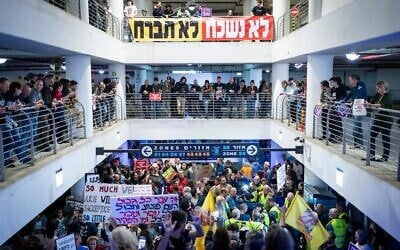 Des manifestants anti-guerre à l’abri dans un parking souterrain alors qu’une sirène retentit pour avertir de l’arrivée de missiles balistiques tirés vers Israël, à Tel Aviv, le 4 avril 2026. (Crédit : Flash90)