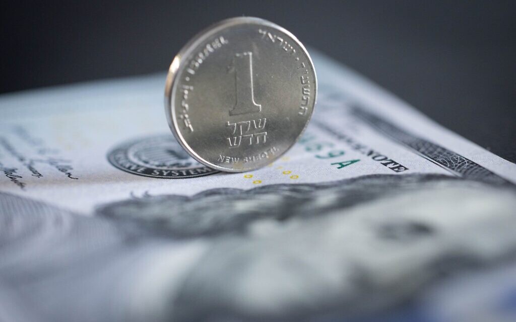 Illustration : Un shekel et un billet de 100 dollars, le 13 avril 2026. (Crédit : Nati Shohat/Flash90) Illustration : Un shekel et un billet de 100 dollars, le 13 avril 2026. (Crédit : Nati Shohat/Flash90)