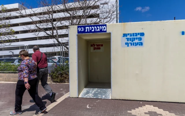 Des Israéliens  à proximité d'un petit abri public dans la ville de Nahariya, au nord d'Israël. 13 avril 2026. (Crédit: Yossi Aloni/FLASH90)