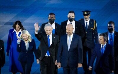 Le Premier ministre Benjamin Netanyahu (au centre), accompagné de son épouse Sara (à sa gauche) et de la ministre des Transports, Miri Regev, ainsi que du président de la Knesset, Amir Ohana et de son partenaire Alon Hadad, arrivant à la 78ᵉ cérémonie d'allumage du flambeau de Yom HaAtsmaout, sur le mont Herzl, à Jérusalem, le 21 avril 2026. (Crédit : Chaïm Goldberg/Flash90)