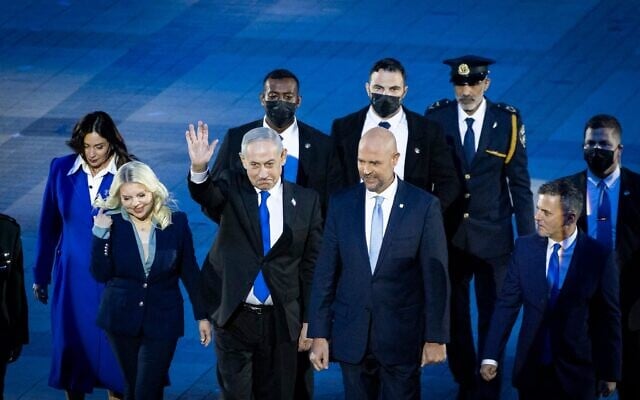 Le Premier ministre Benjamin Netanyahu (au centre), accompagné de son épouse Sara (à sa gauche) et de la ministre des Transports, Miri Regev, ainsi que du président de la Knesset, Amir Ohana et de son partenaire Alon Hadad, arrivant à la 78ᵉ cérémonie d'allumage du flambeau de Yom HaAtsmaout, sur le mont Herzl, à Jérusalem, le 21 avril 2026. (Crédit : Chaïm Goldberg/Flash90)