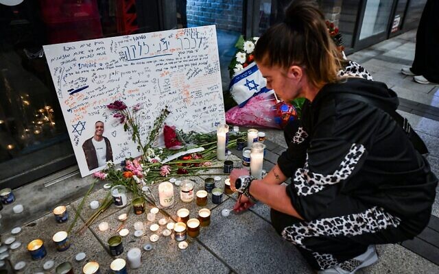 Des personnes allumant des bougies et déposant des fleurs en mémoire de Yemanu Binyamin Zelka, un employé qui y a été poignardé à mort pendant Yom HaAtsmaout devant une pizzeria Pizza Hut, à Petah Tikva, le 25 avril 2026. (Crédit : Avshalom Sassoni/Flash90)