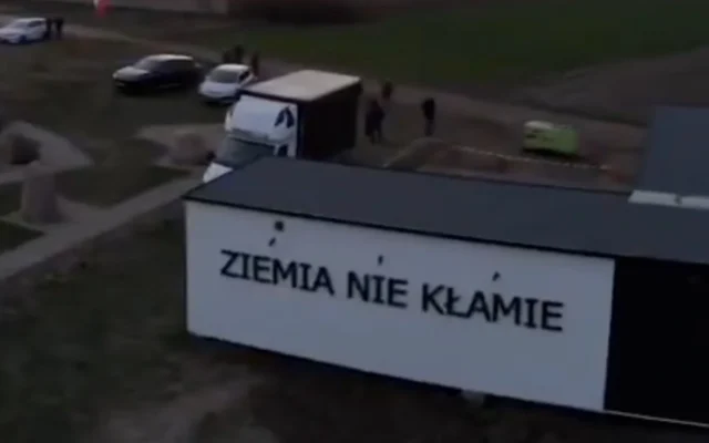 Un conteneur installé près du site du pogrom de Jedwabne proclame en polonais : "La terre ne ment pas". Ce conteneur, installé en avril 2026, promeut le récit laissant entendre que ce sont les nazis, et non les Polonais, qui ont tué les Juifs de Jedwabne en 1941. (Capture d'écran via JTA) Un conteneur installé près du site du pogrom de Jedwabne proclame en polonais : "La terre ne ment pas". Ce conteneur, installé en avril 2026, promeut le récit laissant entendre que ce sont les nazis, et non les Polonais, qui ont tué les Juifs de Jedwabne en 1941. (Capture d'écran via JTA)