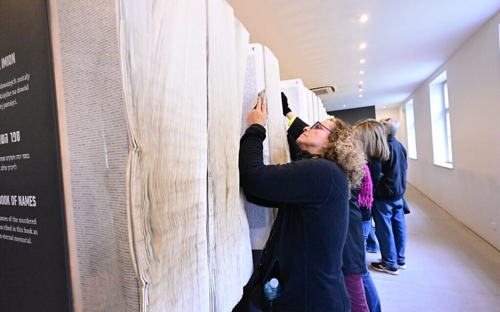 Des visiteurs parcourant le Livre des noms, à Auschwitz, le 13 avril 2026. (Crédit : Yossi Zeliger) Des visiteurs parcourant le Livre des noms, à Auschwitz, le 13 avril 2026. (Crédit : Yossi Zeliger)