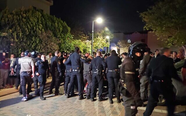 Des policiers sur les lieux où des Haredim radicaux, manifestant contre l'arrestation d'un réfractaire à la conscription, sont entrés par effraction dans le jardin de la maison du chef de la police militaire, le général de brigade Yuval Yamin, à Ashkelon, le 28 avril 2026. (Crédit : Police israélienne) Des policiers sur les lieux où des Haredim radicaux, manifestant contre l'arrestation d'un réfractaire à la conscription, sont entrés par effraction dans le jardin de la maison du chef de la police militaire, le général de brigade Yuval Yamin, à Ashkelon, le 28 avril 2026. (Crédit : Police israélienne)