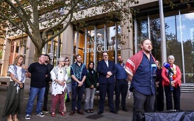 Josh Lees (à droite), du groupe Palestine Action, s'adressant à des représentants de neuf organisations de la société civile alors qu'il annonce le dépôt d'un recours constitutionnel contre les lois relatives aux manifestations, devant la Cour suprême de Nouvelle-Galles du Sud, dans le centre de Sydney, le 17 mars 2025. (Crédit : David Gray/AFP)
