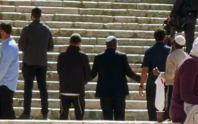 Le ministre de la Sécurité nationale, Itamar Ben Gvir, de dos, les bras ouverts en prière sur le mont du Temple, dans la Vieille Ville de Jérusalem, le 12 avril 2026. (Crédit : Capture d'écran/X ; utilisée conformément à l'article 27a de la loi sur le droit d'auteur)