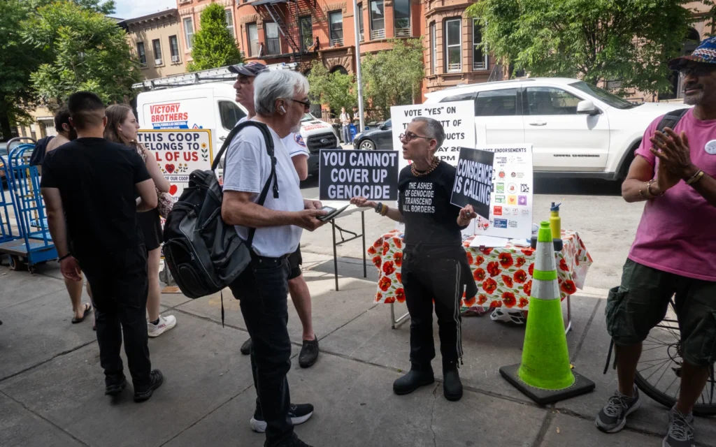Des militants pro et anti-BDS sur le trottoir devant la Park Slope Food Coop de Brooklyn, à New York, le 26 mai 2026. (Luke Tress/Times of Israel)