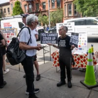 Des militants pro et anti-BDS sur le trottoir devant la Park Slope Food Coop de Brooklyn, à New York, le 26 mai 2026. (Luke Tress/Times of Israel)
