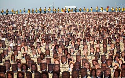 Des membres de la communauté bahaïe manifestent sur la plage de Copacabana, à Rio de Janeiro, le 19 juin 2011 pour réclamer aux autorités iraniennes la libération sept prisonniers bahaïs accusés d'espionnage au profit d'Israël et condamnés à 20 ans de prison. (Crédit : ANA CAROLINA FERNANDES / AFP)